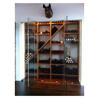 Zebra wood wine shelving behind frame less glass illuminated by LED lighting. Wine Guardian cooling system.